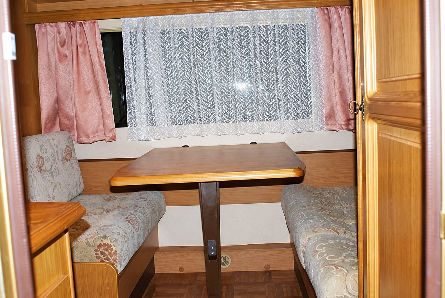 Coin repas de la caravane 1, table entourée de banquettes